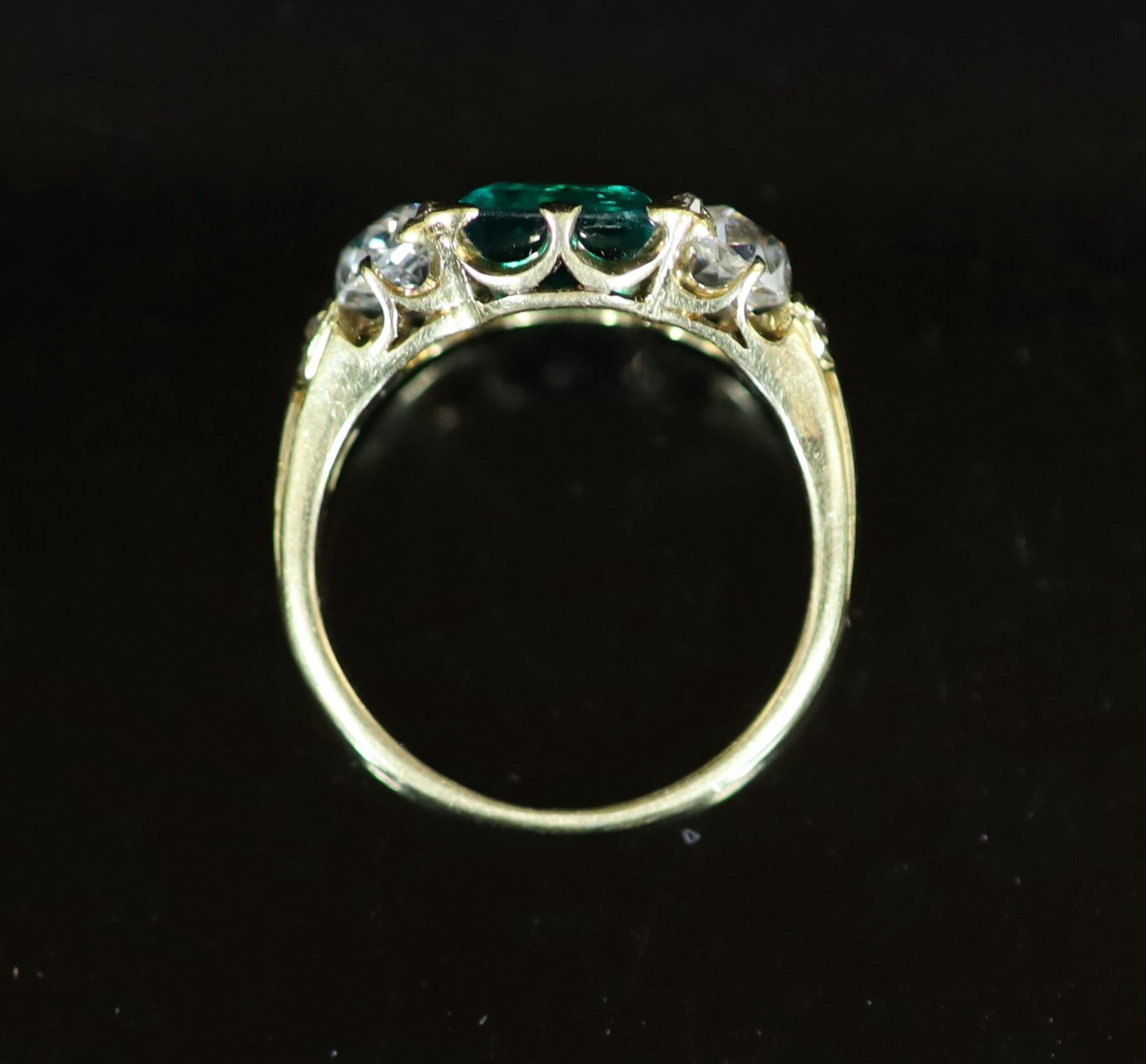 A good early 20th century gold, single stone trap cut emerald and two stone old cut diamond set ring